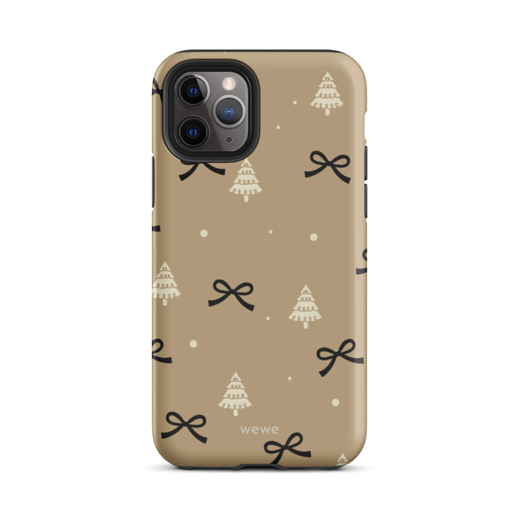 Custom iPhone 11 pro tough case in matte taupe/khaki brown featuring a scattered holiday pattern of small black bows, white doodle Christmas trees, and white snowflakes/dots, with 'wewe' branding at the bottom.