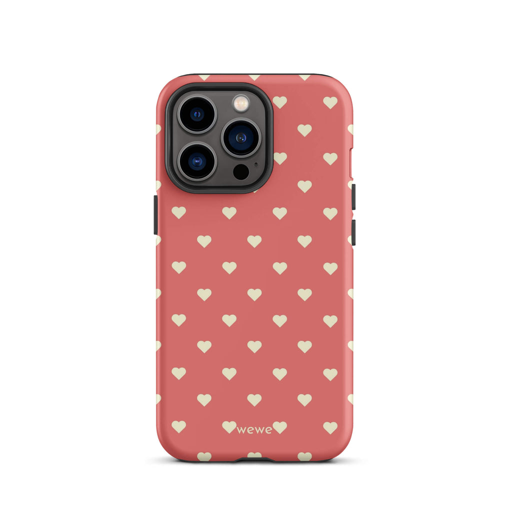 Coral-pink iPhone case with evenly spaced soft-cream mini hearts