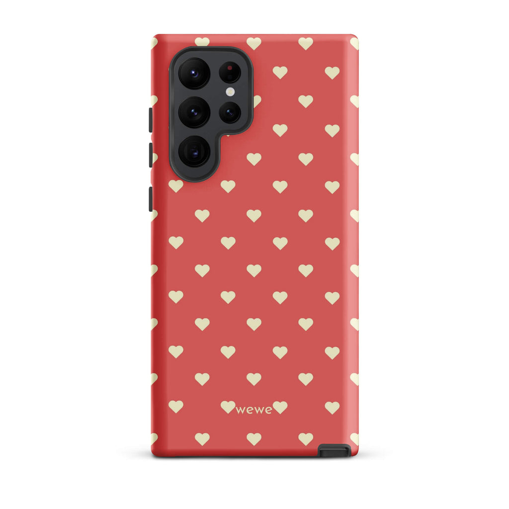 Coral-pink iPhone case with evenly spaced soft-cream mini hearts