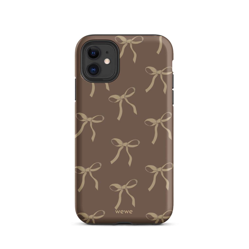 Custom iPhone 11 tough case in matte dark espresso brown featuring an all-over repeating pattern of light taupe/tan ribbons/bows, with 'wewe' branding at the bottom.