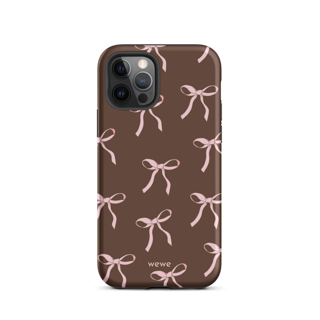 Custom iPhone 12 pro tough case in matte dark brown (chocolate) featuring an all-over repeating pattern of light pink ribbons/bows, with 'wewe' branding at the bottom.