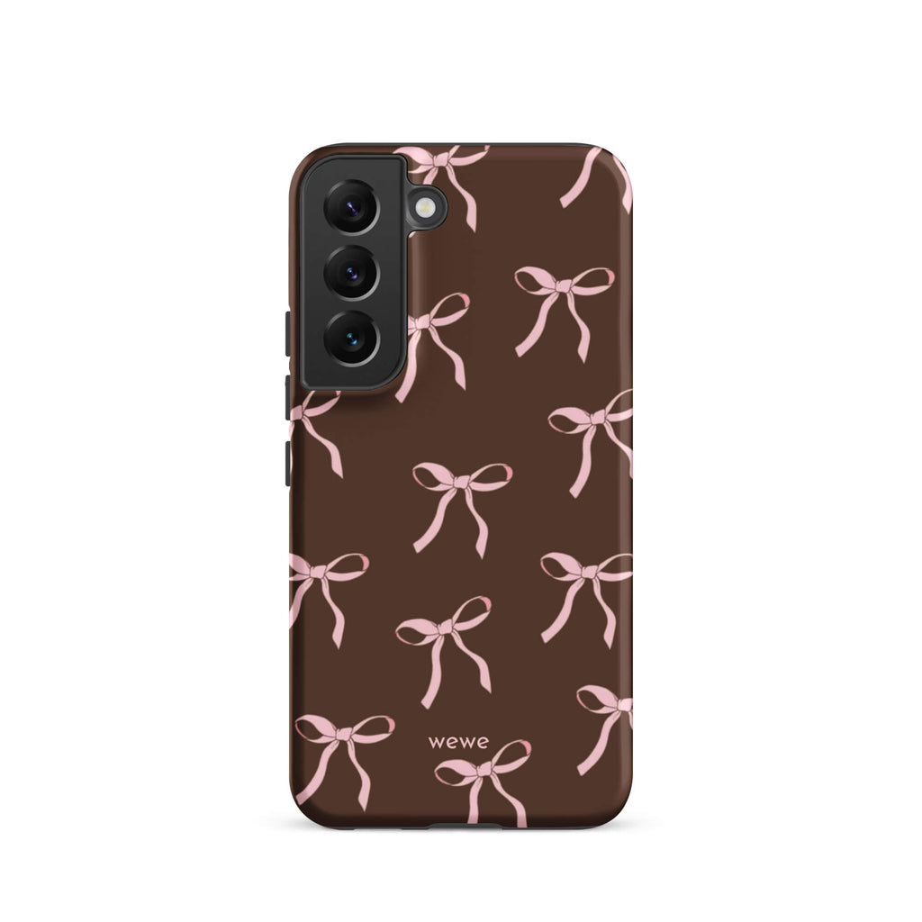 Custom samsung galaxy s22 tough case in matte dark brown (chocolate) featuring an all-over repeating pattern of light pink ribbons/bows, with 'wewe' branding at the bottom.