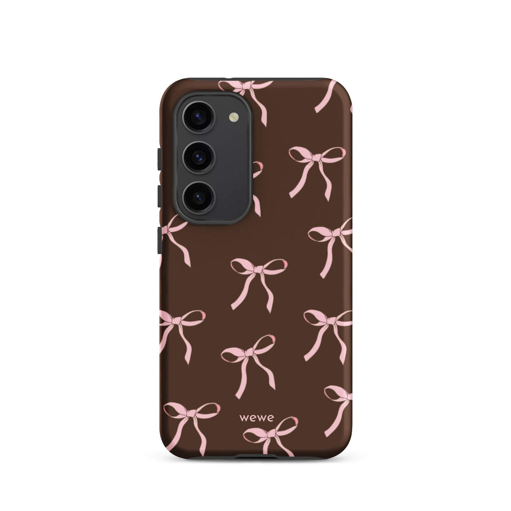 Custom samsung galaxy s23 tough case in matte dark brown (chocolate) featuring an all-over repeating pattern of light pink ribbons/bows, with 'wewe' branding at the bottom.