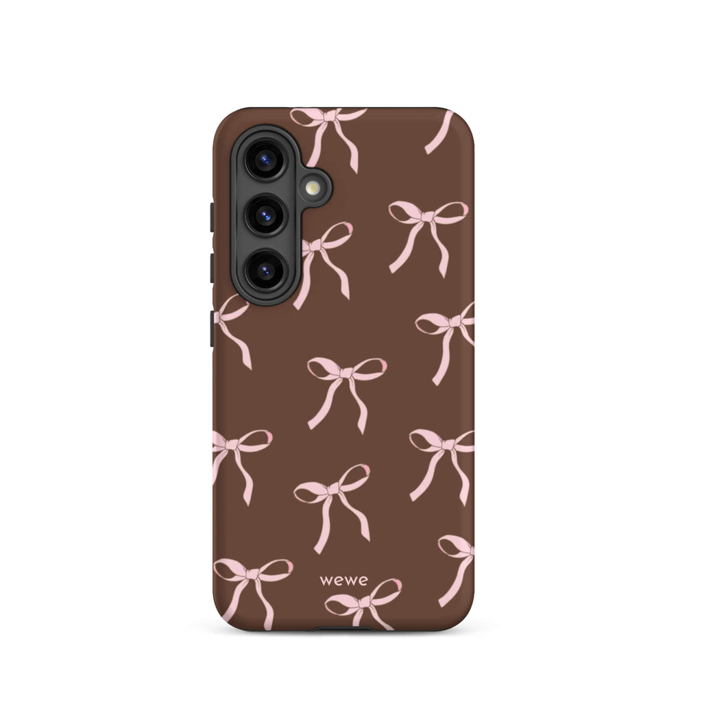 Custom samsung galaxy s24 tough case in matte dark brown (chocolate) featuring an all-over repeating pattern of light pink ribbons/bows, with 'wewe' branding at the bottom.