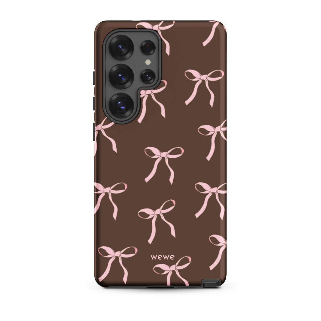 Custom samsung galaxy s25 ultra tough case in matte dark brown (chocolate) featuring an all-over repeating pattern of light pink ribbons/bows, with 'wewe' branding at the bottom.