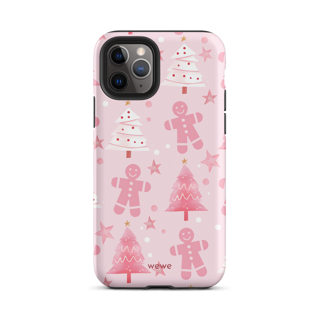 Custom iPhone 11 pro tough case featuring a soft pastel pink background with a scattered pattern of pink gingerbread men, pink and white Christmas trees, and watercolor pink stars, with 'wewe' branding at the bottom.