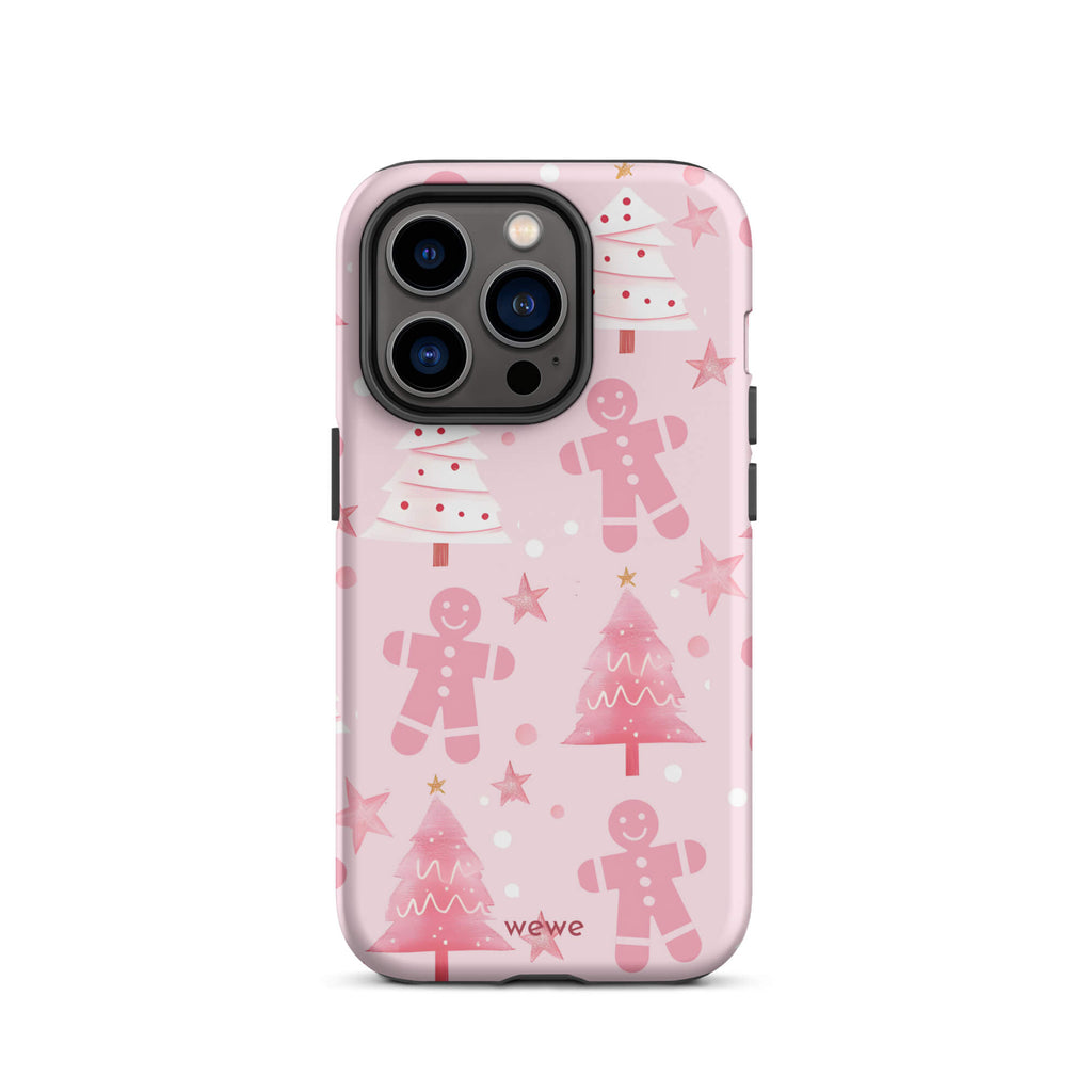 Custom iPhone 14 pro tough case featuring a soft pastel pink background with a scattered pattern of pink gingerbread men, pink and white Christmas trees, and watercolor pink stars, with 'wewe' branding at the bottom.