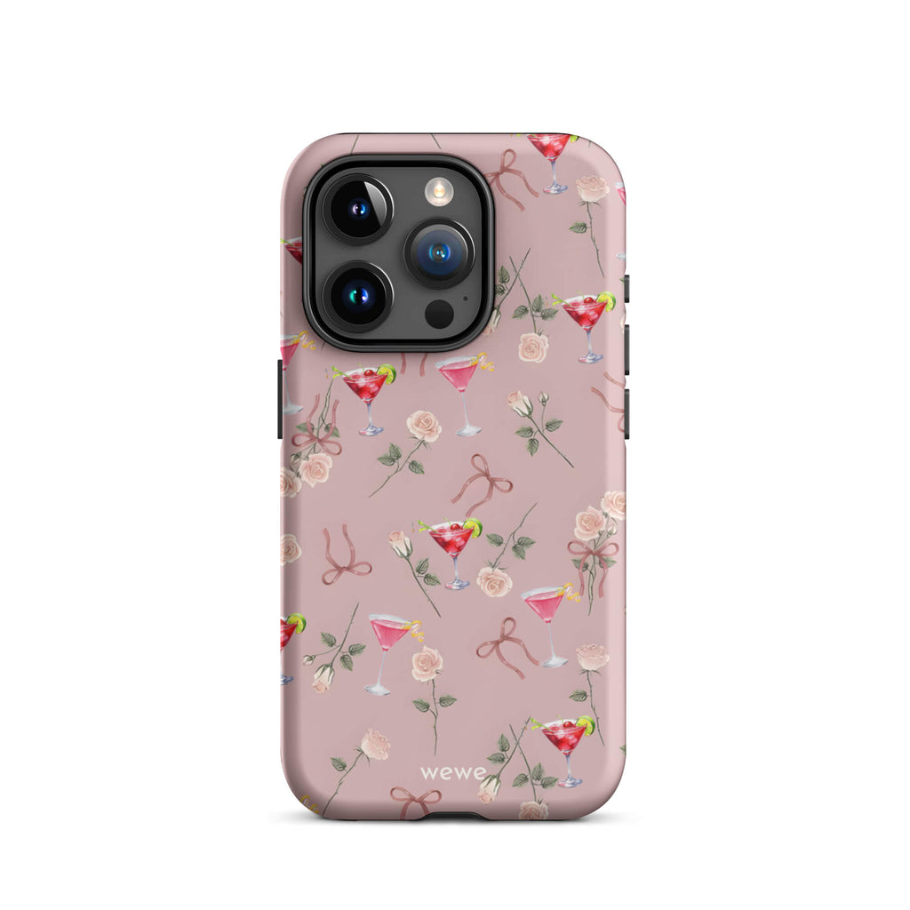 Custom iPhone case 15 pro with a repeating pattern of pink roses, ribbon bows, and red cocktail glasses on a light rose colour background.