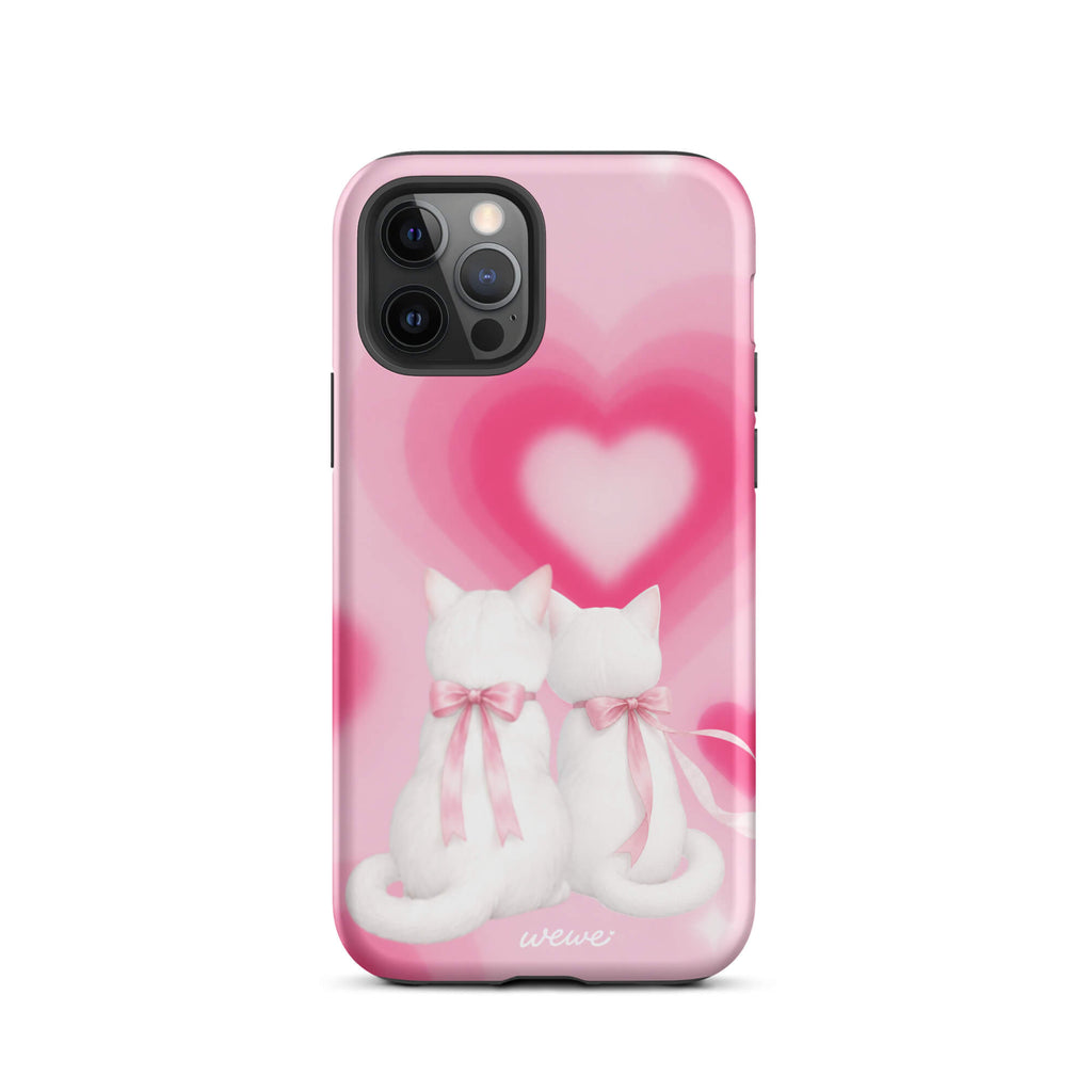 Blush-pink iPhone case with two white cats, pink bows and a layered soft-focus heart
