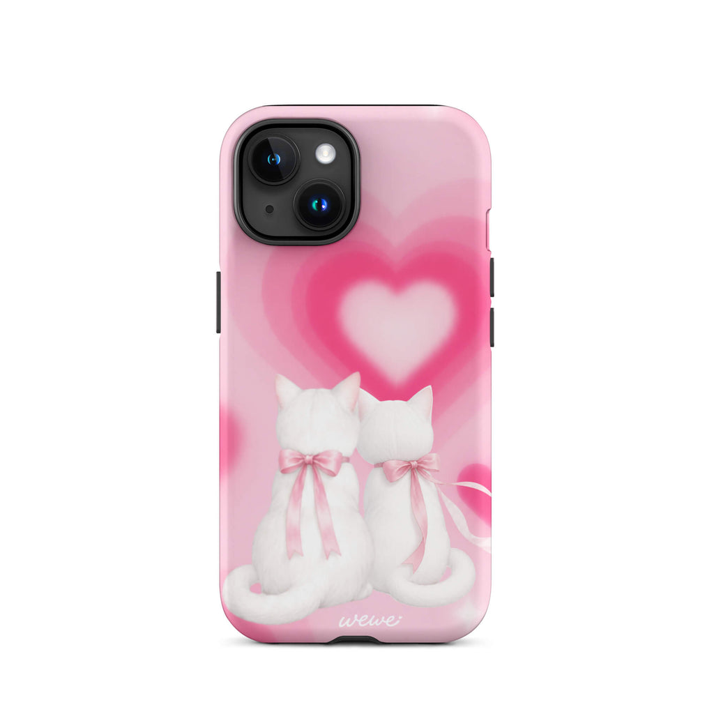 Blush-pink iPhone case with two white cats, pink bows and a layered soft-focus heart