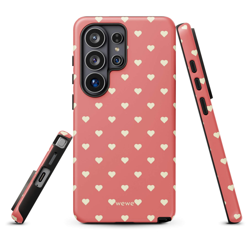 Coral-pink iPhone case with evenly spaced soft-cream mini hearts