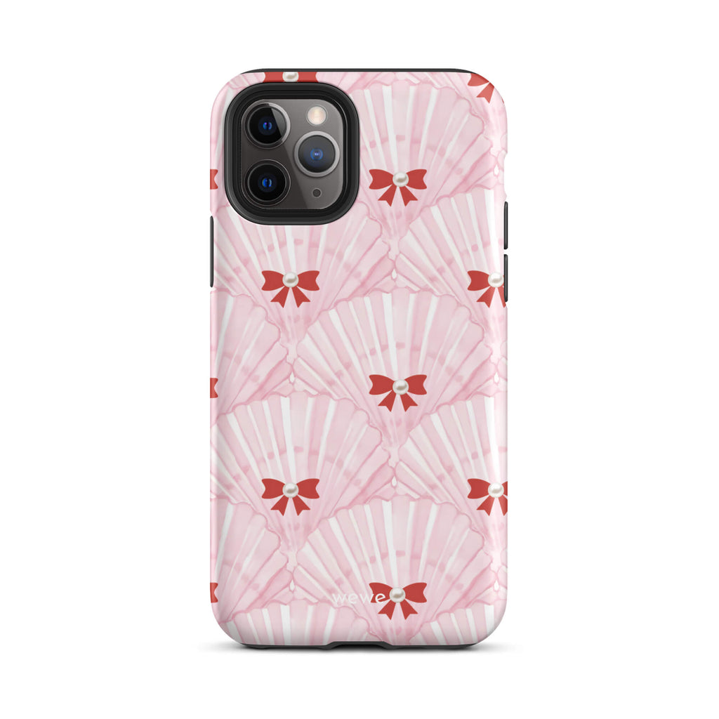Custom iPhone case 11 pro with a cute and whimsical pattern of watercolor pink and white seashells with red bows and pearls.