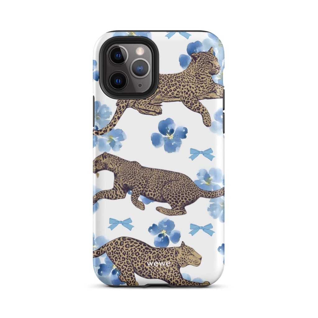 Custom iPhone case 11 pro with a cute pattern of leopard print cheetahs, blue pansies, and small ribbons on a white background.