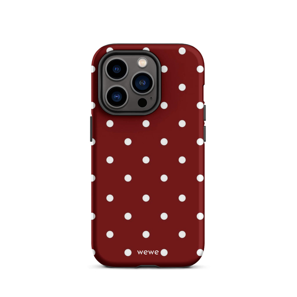 Custom iPhone case 14 pro with a maroon red background and a pattern of small white polka dots.