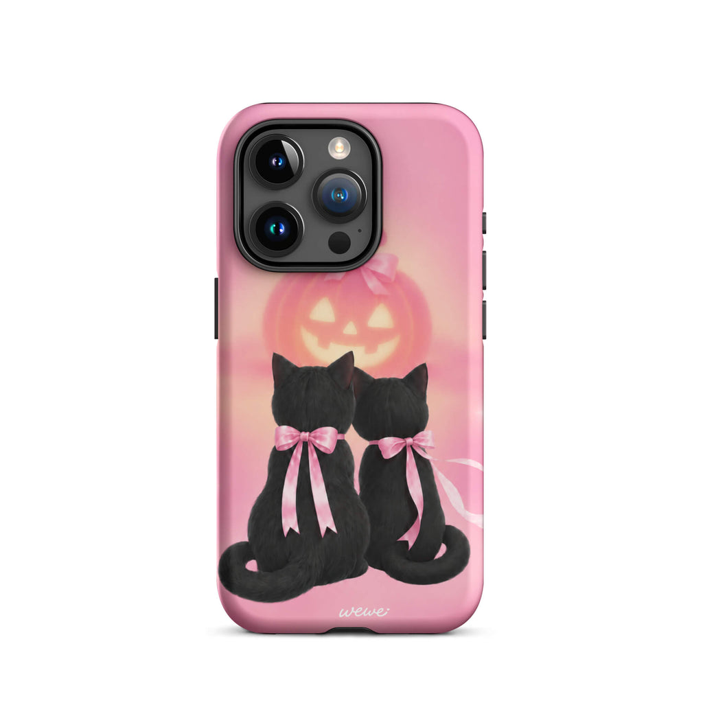 Bubblegum-pink iPhone case with two black cats wearing pink bows and a glowing jack-o-lantern