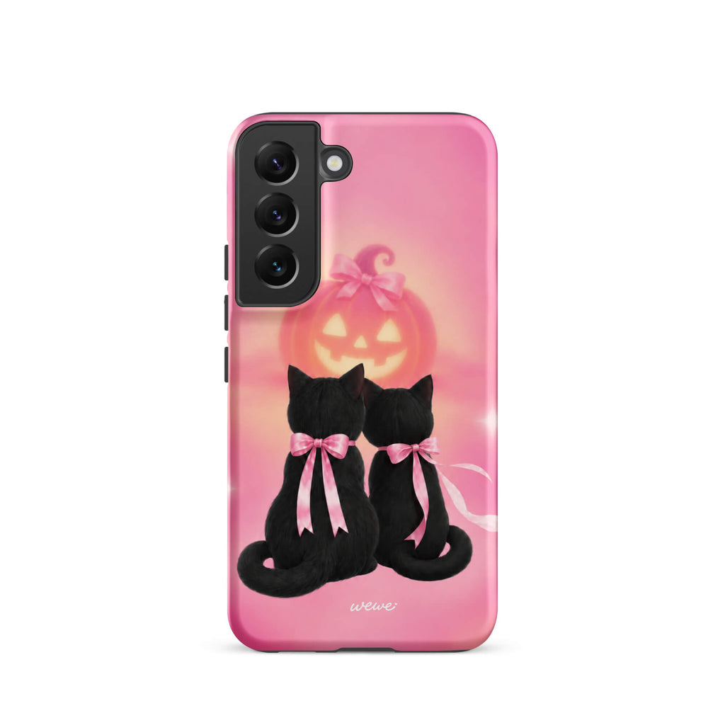 Bubblegum-pink iPhone case with two black cats wearing pink bows and a glowing jack-o-lantern