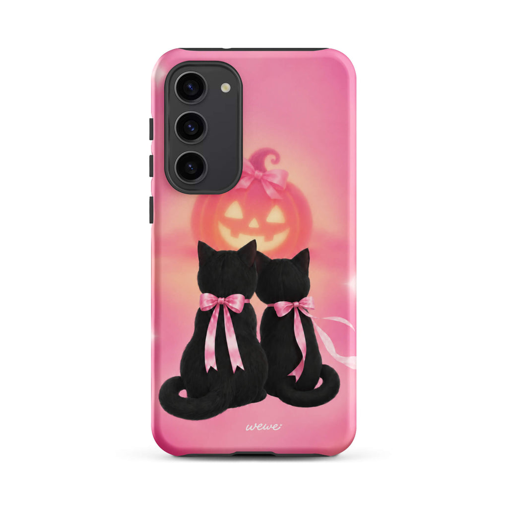 Bubblegum-pink iPhone case with two black cats wearing pink bows and a glowing jack-o-lantern
