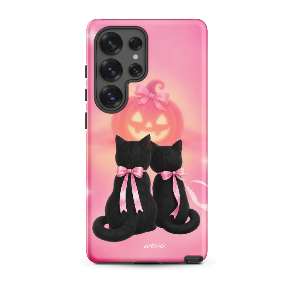 Bubblegum-pink iPhone case with two black cats wearing pink bows and a glowing jack-o-lantern