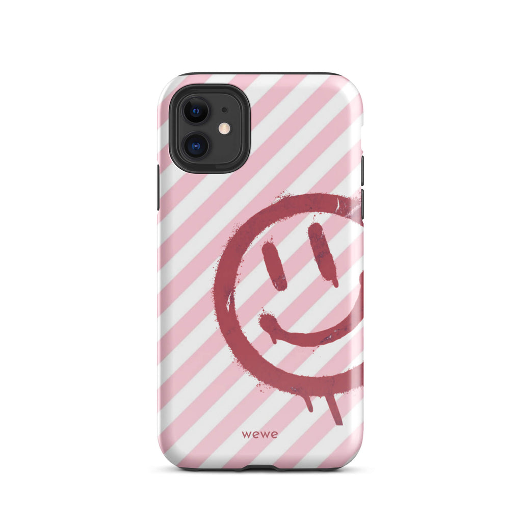 Custom iPhone case 11 with a pink and white diagonal stripe background and a red spray paint graffiti smiley face.