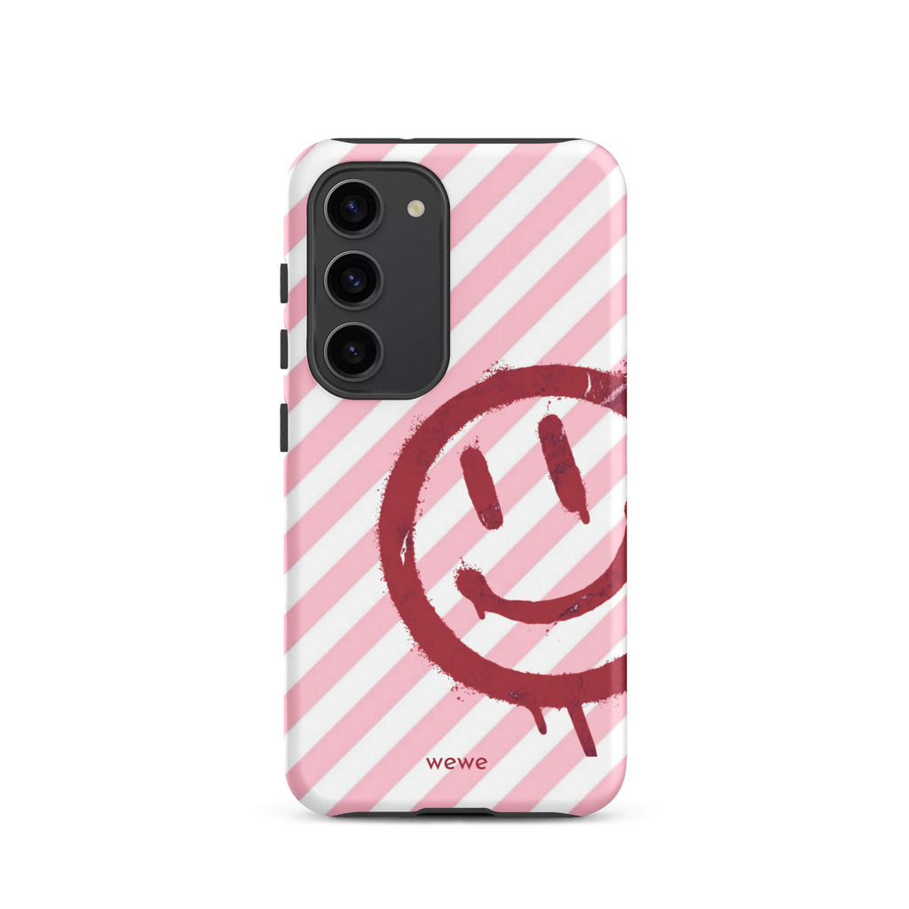 Custom samsung galaxy s23 Phone case with a pink and white diagonal stripe background and a red spray paint graffiti smiley face.