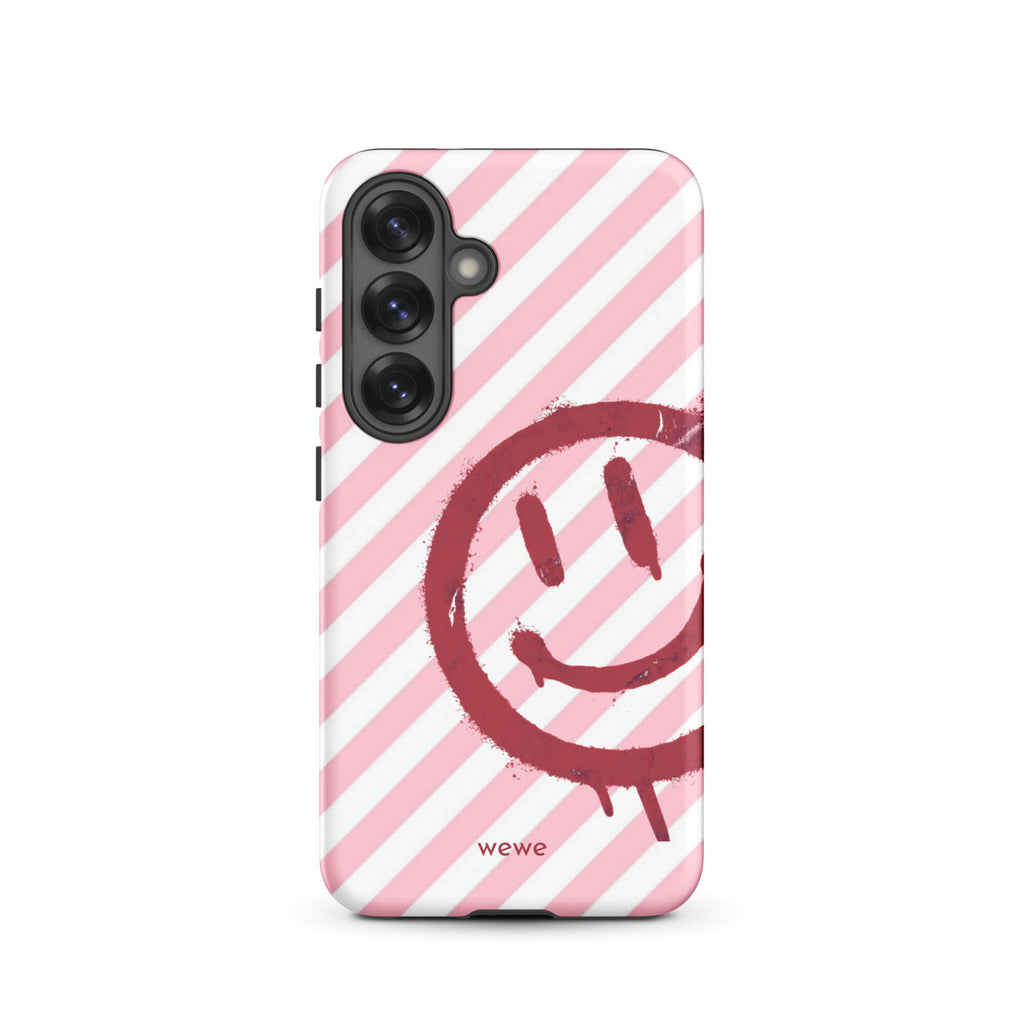 Custom samsung galaxy s25 Phone case with a pink and white diagonal stripe background and a red spray paint graffiti smiley face.