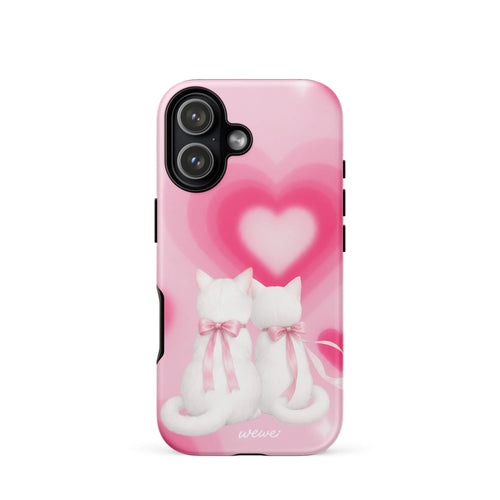 Blush-pink iPhone case with two white cats, pink bows and a layered soft-focus heart